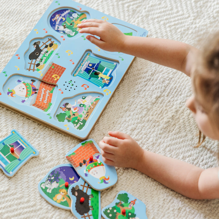 A kid playing with The Melissa & Doug Nursery Rhymes 1 Sound Puzzle - 6 PIeces