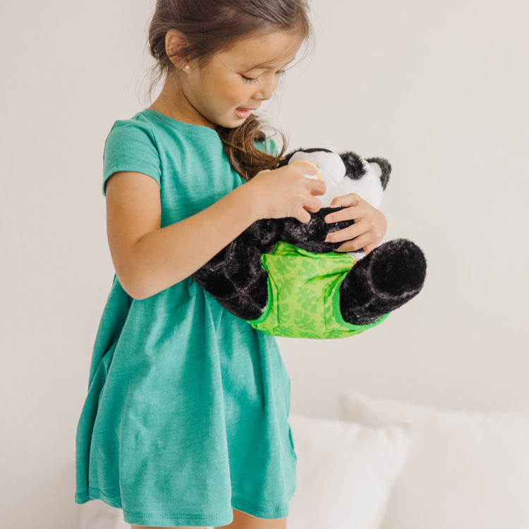 A kid playing with The Melissa & Doug 11-Inch Baby Panda Plush Stuffed Animal with Pacifier, Diaper, Baby Bottle