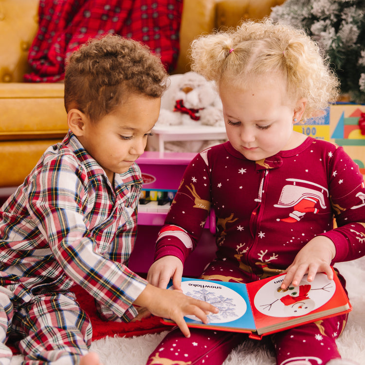 A kid playing with The Melissa & Doug Children’s Book – Poke-a-Dot: Christmas (Board Book with Buttons to Pop)