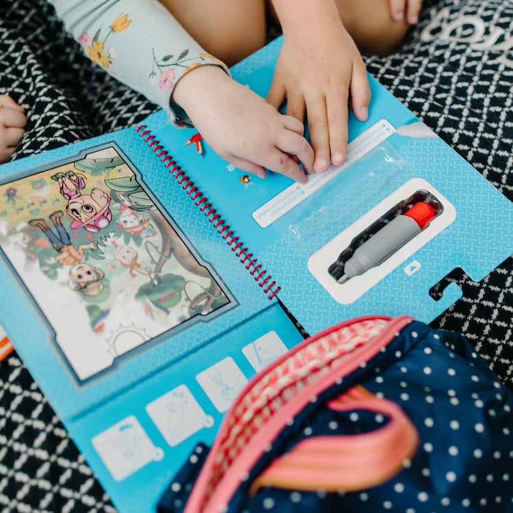 A kid playing with The Melissa & Doug PAW Patrol Water Wow! - Skye Water Reveal Travel Activity Pad