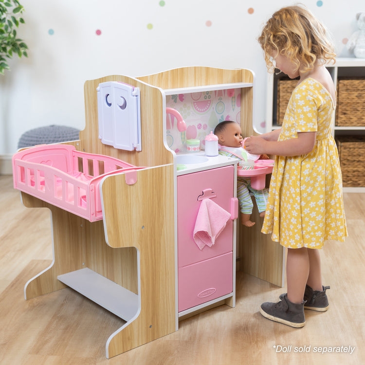 A kid playing with The Melissa & Doug Baby Care Center and Accessory Sets