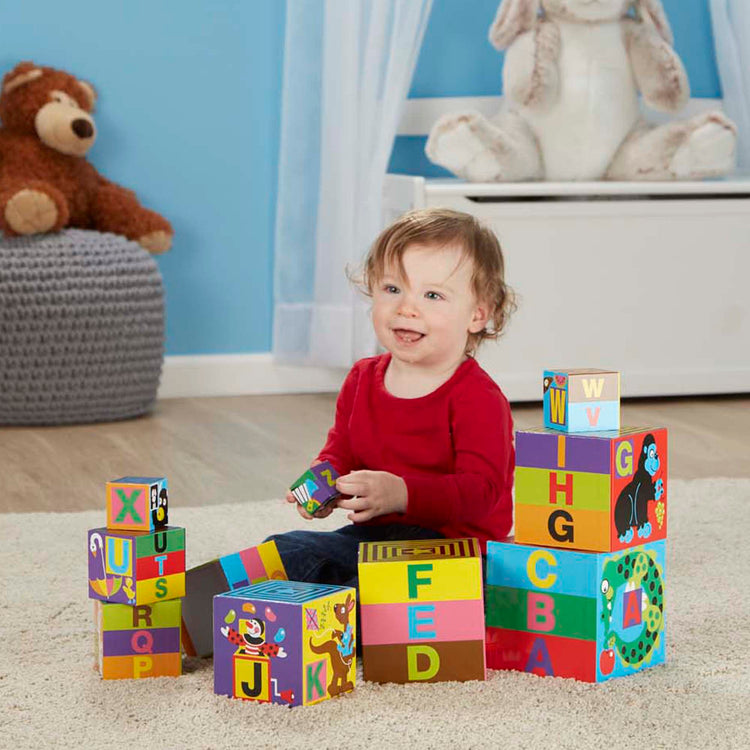 A kid playing with The Melissa & Doug Deluxe 10-Piece Alphabet Nesting and Stacking Blocks