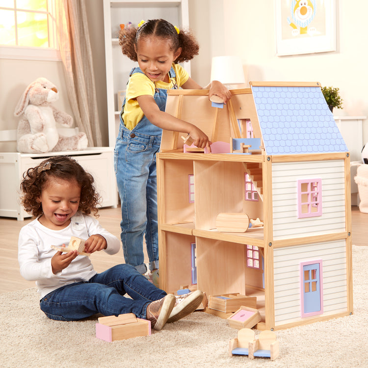 A kid playing with The Melissa & Doug Modern Wooden Multi-Level Dollhouse With 19 pcs Furniture [White]