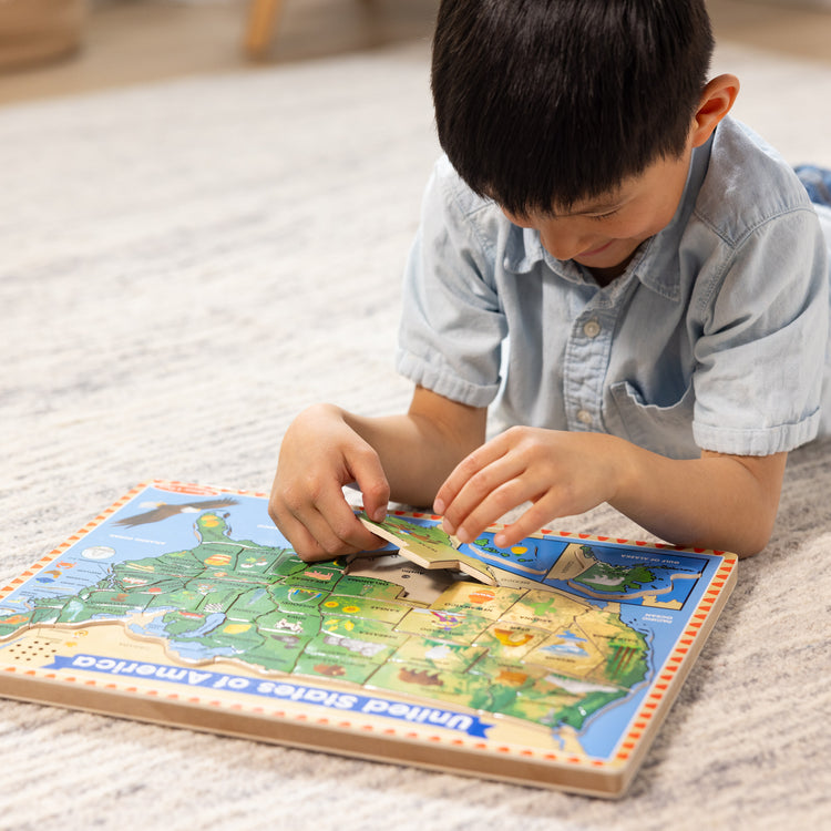 A kid playing with The Melissa & Doug USA Map Sound Puzzle - Wooden Puzzle With Sound Effects (40 pcs), Multicolor