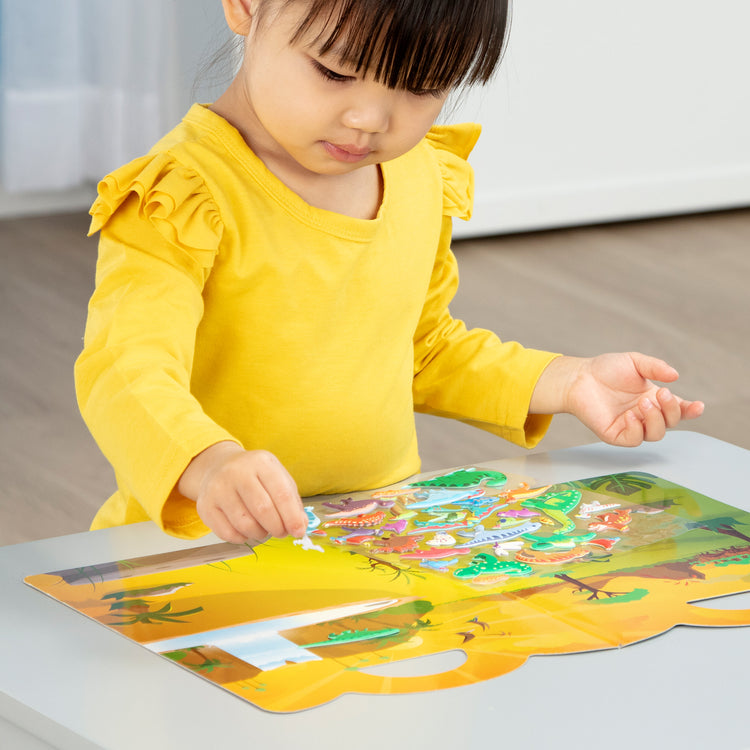 A kid playing with The Melissa & Doug Dinosaur Puffy Sticker Play Set Travel Toy with Double-Sided Background, 36 Reusable Puffy Stickers