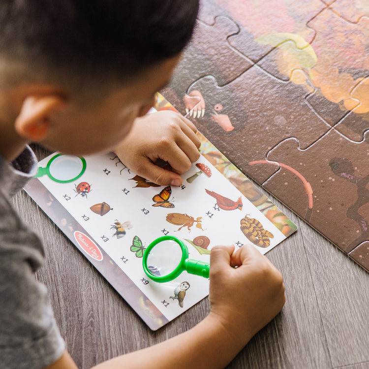 A kid playing with The Melissa & Doug Double-Sided Seek & Find Puzzle