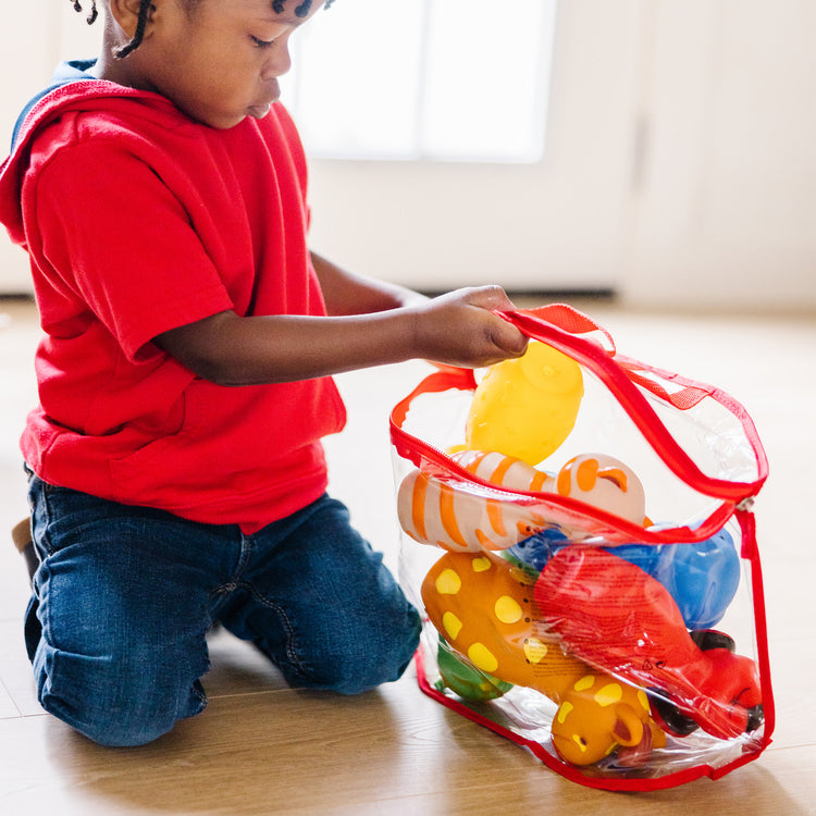 A kid playing with The Melissa & Doug K's Kids Bowling Friends Play Set and Game With 6 Pins and Convenient Carrying Case