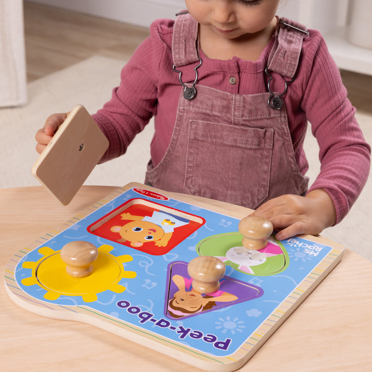 A kid playing with The Melissa & Doug® Ms. Rachel™ Wooden Peek-a-Boo Jumbo Peg Puzzle, 4-Piece with Mirror, Toddler Toys for Boys and Girls Ages 1+ Years

