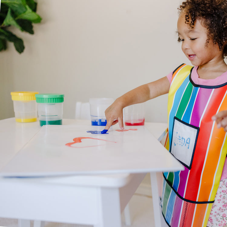 A kid playing with The Melissa & Doug Finger Paint Paper Pad - 50 12"x18" Sheets for Kids Arts And Crafts Age 2+