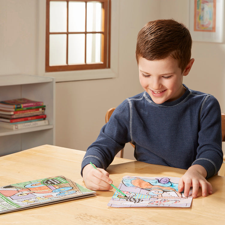 A kid playing with The Melissa & Doug My First Paint With Water Coloring Book - Vehicles (24 Painting Pages)