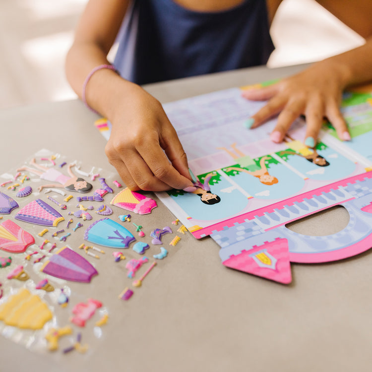 A kid playing with The Melissa & Doug Puffy Sticker Set: Princess - 67 Reusable Stickers