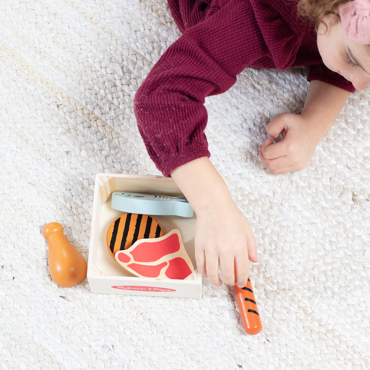 A kid playing with The Melissa & Doug Wooden Food Groups Play Food Set – Protein