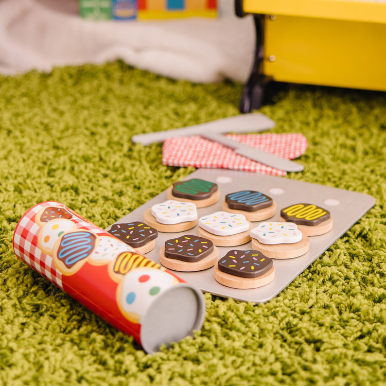 A kid playing with The Melissa & Doug Slice and Bake Wooden Cookie Play Food Set