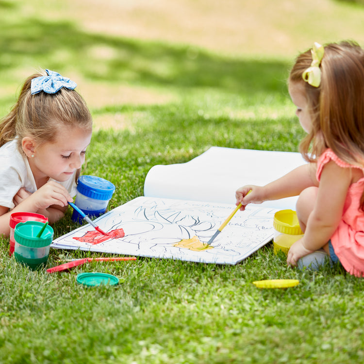 A kid playing with The Melissa & Doug Art Essentials Easel Pad (17 x 20 inches) With 50 Sheets of White Bond Paper