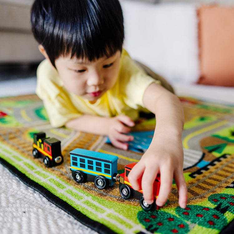 A kid playing with The Melissa & Doug Wooden Magnetic Train Cars - 8 Piece Educational and Skill-Building Wooden Toy for Boys and Girls