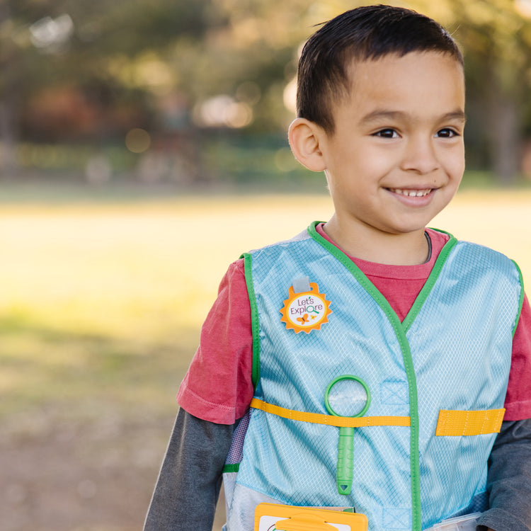 A kid playing with The Melissa & Doug Let’s Explore Naturalist Vest Play Set – 20 Pieces