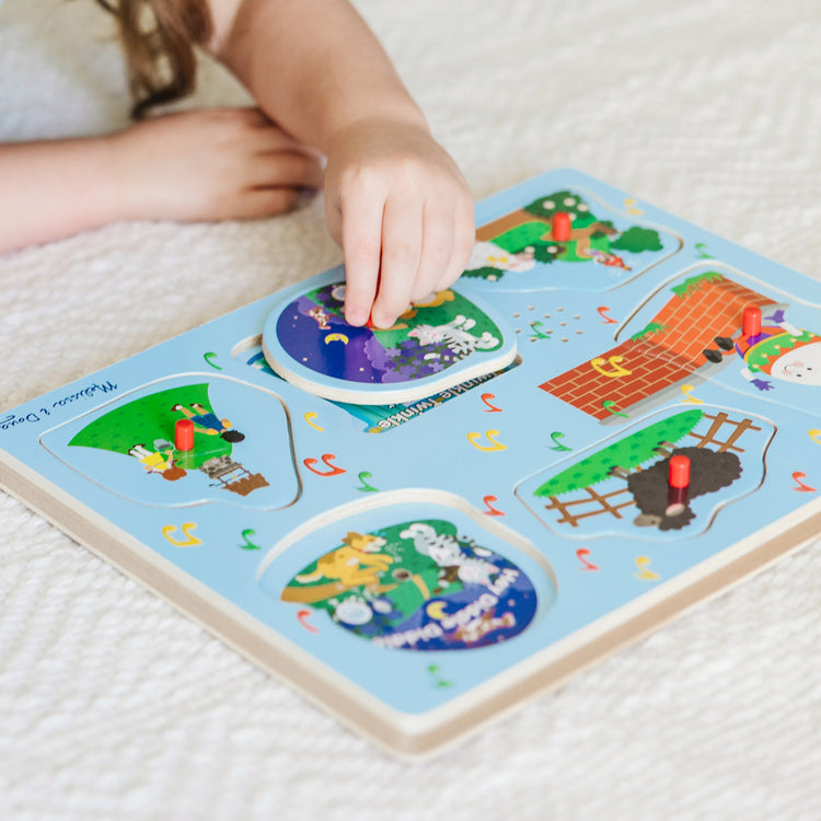 A kid playing with The Melissa & Doug Nursery Rhymes 1 Sound Puzzle - 6 PIeces