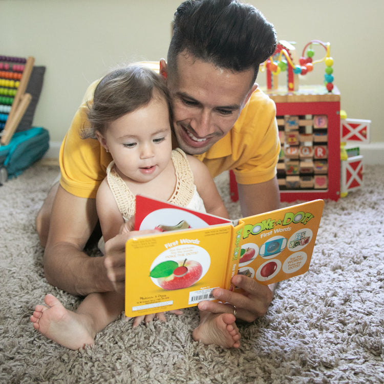 A kid playing with The Melissa & Doug Children’s Book – Poke-a-Dot: First Words (Board Book with Buttons to Pop)