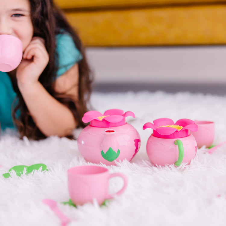 A kid playing with The Melissa & Doug Butterfly Tea Set (15 pcs) - Play Food Accessories