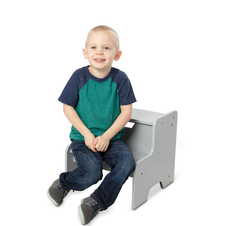 A child on white background with The Melissa & Doug Kids Furniture Wooden Step Stool - Gray