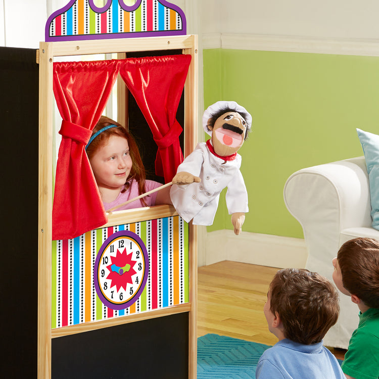 A kid playing with The Melissa & Doug Chef Puppet (Al Dente) with Detachable Wooden Rod