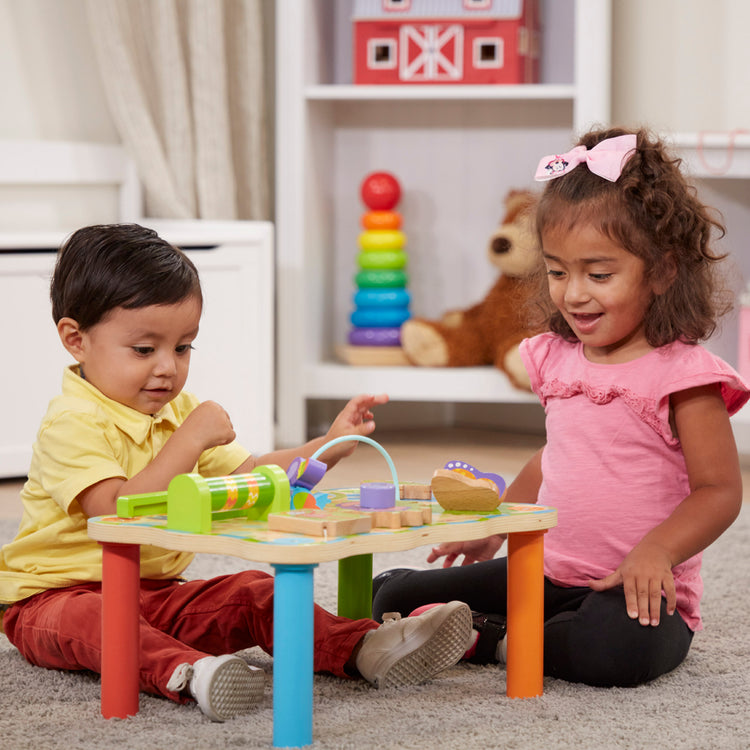 A kid playing with The Melissa & Doug First Play Children’s Jungle Wooden Activity Table for Toddlers