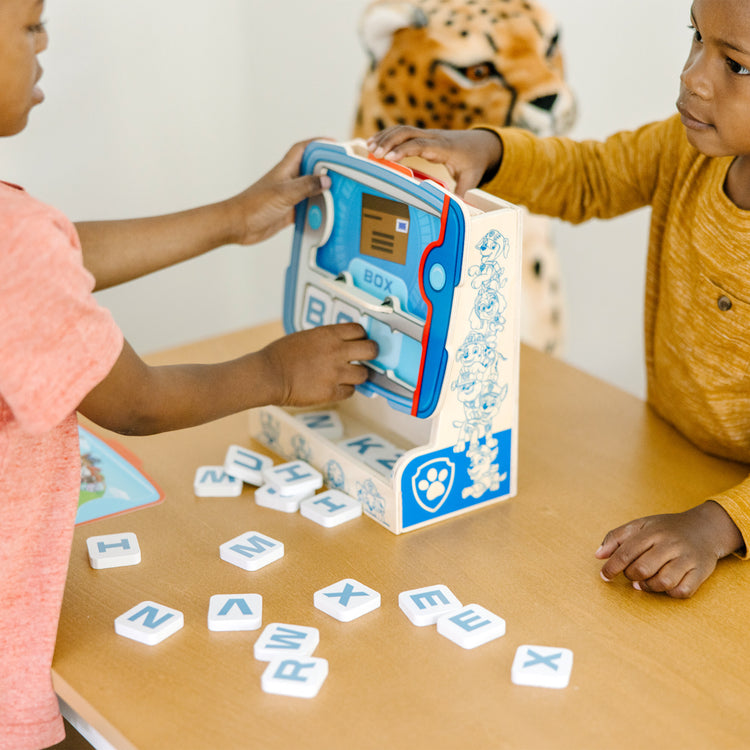 A kid playing with The Melissa & Doug PAW Patrol Wooden See & Spell Pup Pad Game