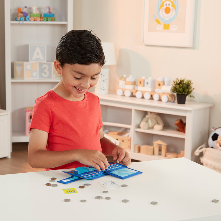 A kid playing with The Melissa & Doug Pretend-to-Spend Toy Wallet With Play Money and Cards (45 pcs), Blue