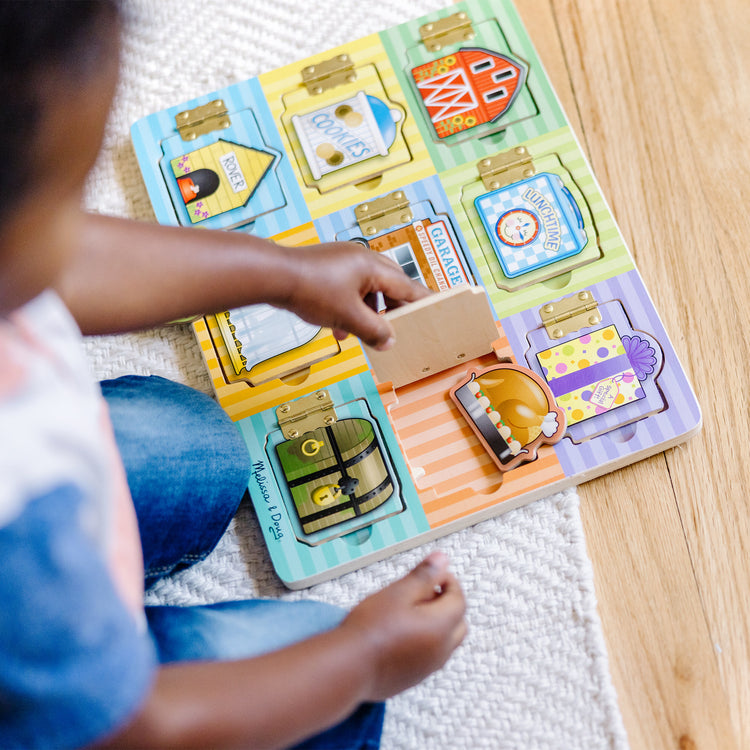 A kid playing with The Melissa & Doug Hide and Seek Wooden Activity Board With Wooden Magnets