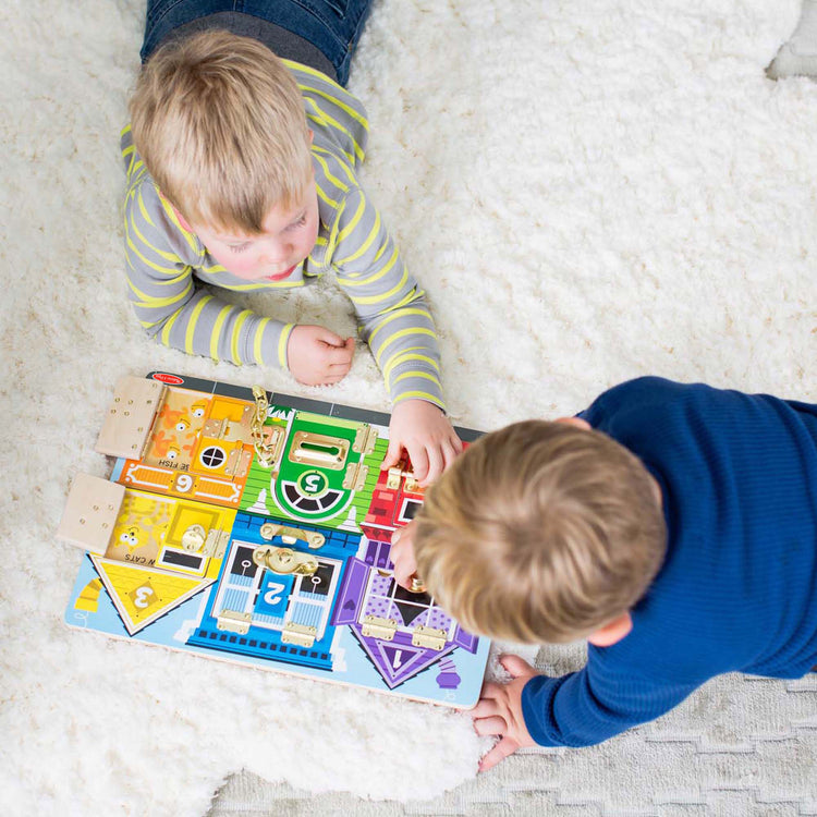 A kid playing with The Melissa & Doug Latches Wooden Activity Board