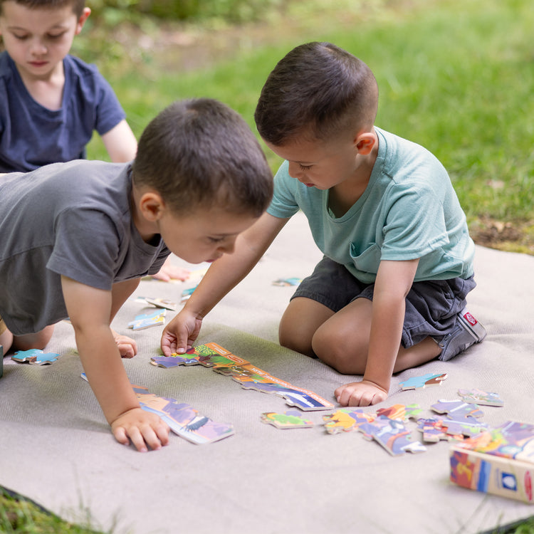 A kid playing with The Melissa & Doug Grand Canyon National Park Wooden Jigsaw Puzzle – 24 Pieces, Animal and Plant ID Guide