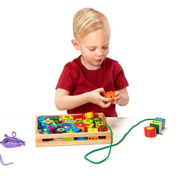 A child on white background with The Melissa & Doug Deluxe Wooden Lacing Beads - Educational Activity With 27 Beads and 2 Laces