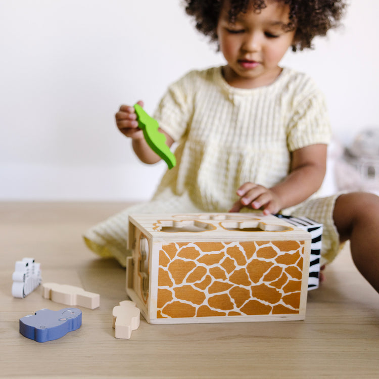 A kid playing with The Melissa & Doug Animal Rescue Shape-Sorting Truck - Wooden Toy With 7 Animals and 2 Play Figures