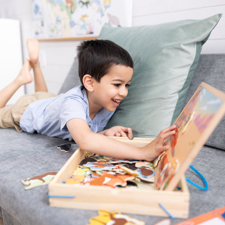 A kid playing with The Melissa & Doug National Parks Wooden Picture Matching Magnetic Game