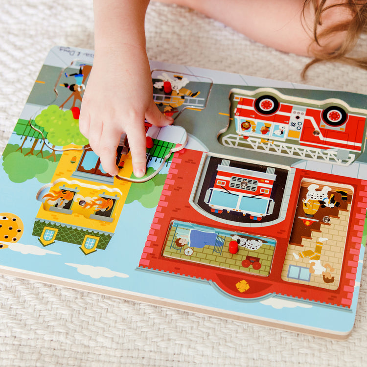 A kid playing with The Melissa & Doug Around the Fire Station Sound Puzzle - Wooden Peg Puzzle (8 pcs)