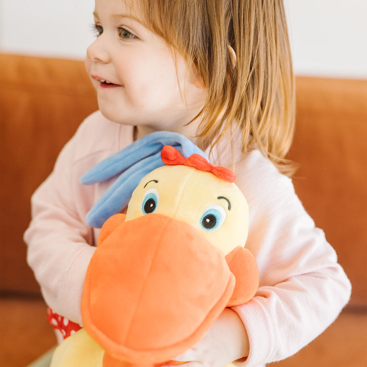 A kid playing with The Melissa & Doug K's Kids Hungry Pelican Soft Baby Educational Toy