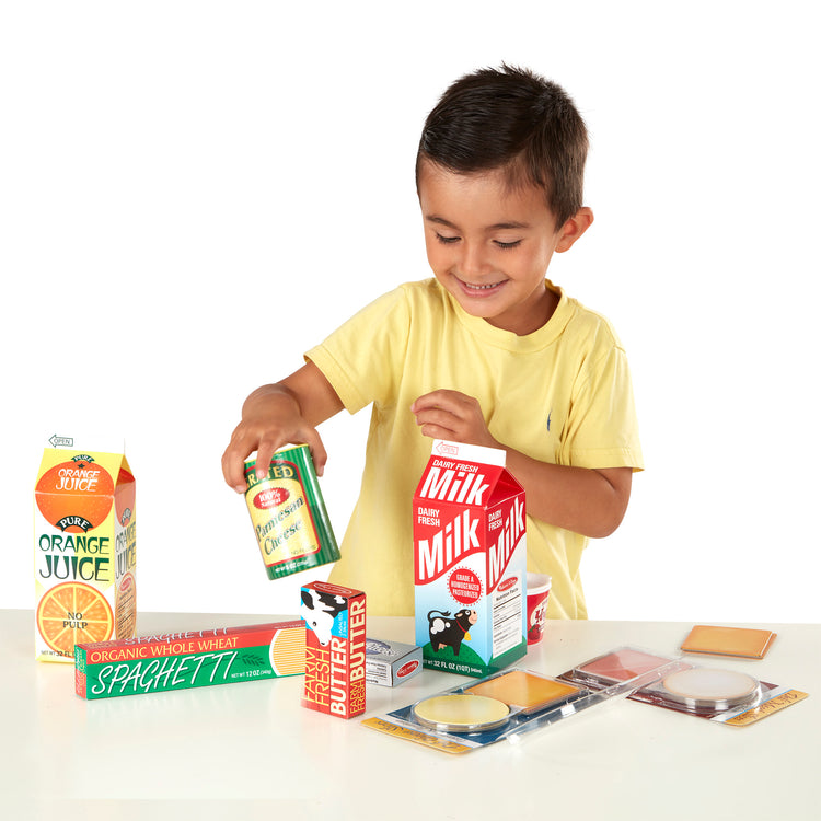 A kid playing with The Melissa & Doug Fridge Groceries Play Food Cartons (8 pieces)