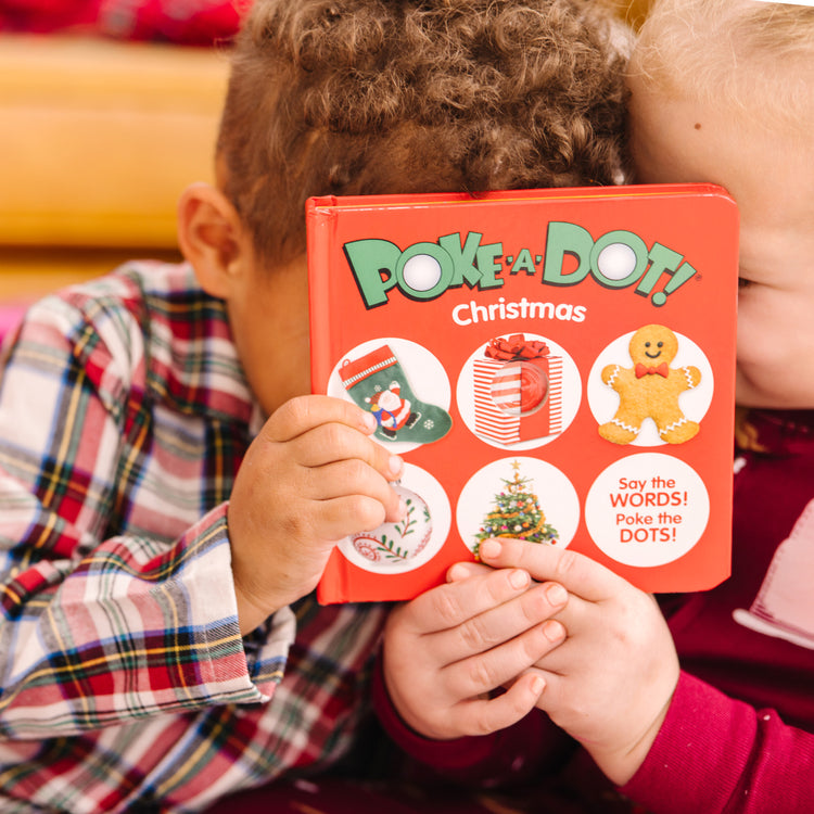 A kid playing with The Melissa & Doug Children’s Book – Poke-a-Dot: Christmas (Board Book with Buttons to Pop)