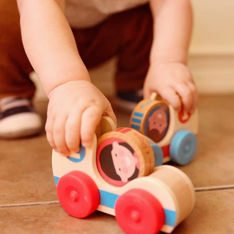 A kid playing with The Melissa & Doug GO Tots Wooden Race Cars (2 Cars, 2 Disks)