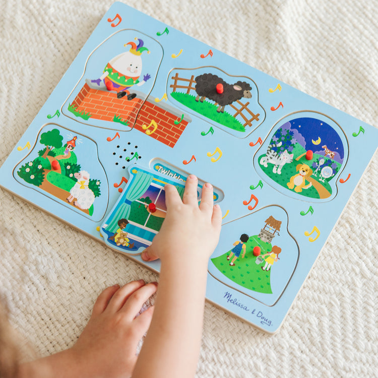 A kid playing with The Melissa & Doug Nursery Rhymes 1 Sound Puzzle - 6 PIeces