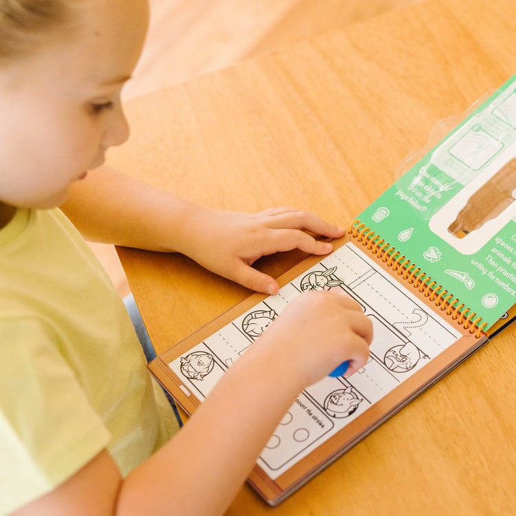 A kid playing with The Melissa & Doug On the Go Water Wow! Reusable Water-Reveal Activity Pad - Numbers