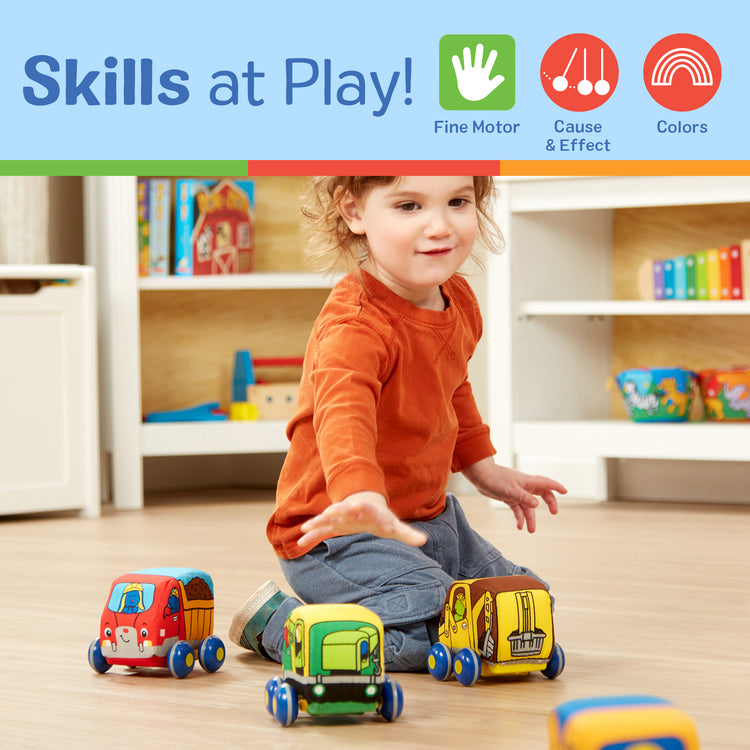 A kid playing with The Melissa & Doug Pull-Back Construction Vehicles - Soft Baby Toy Play Set of 4 Vehicles