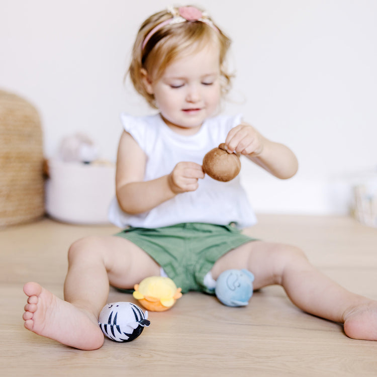 A kid playing with The Melissa & Doug Rollables Safari Friends Infant and Toddler Toy (4 Pieces)