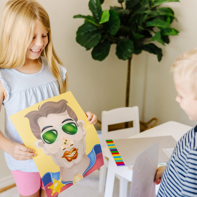 A kid playing with The Melissa & Doug Make-a-Face Sticker Pad - Crazy Characters, 20 Faces, 5 Sticker Sheets