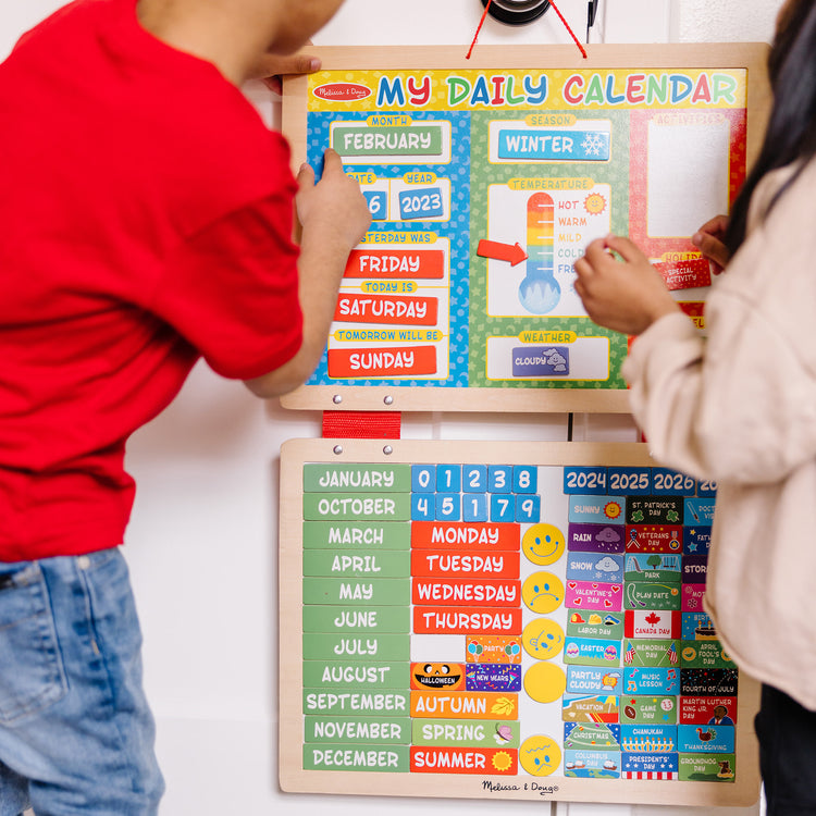 A kid playing with The Melissa & Doug My First Daily Magnetic Calendar