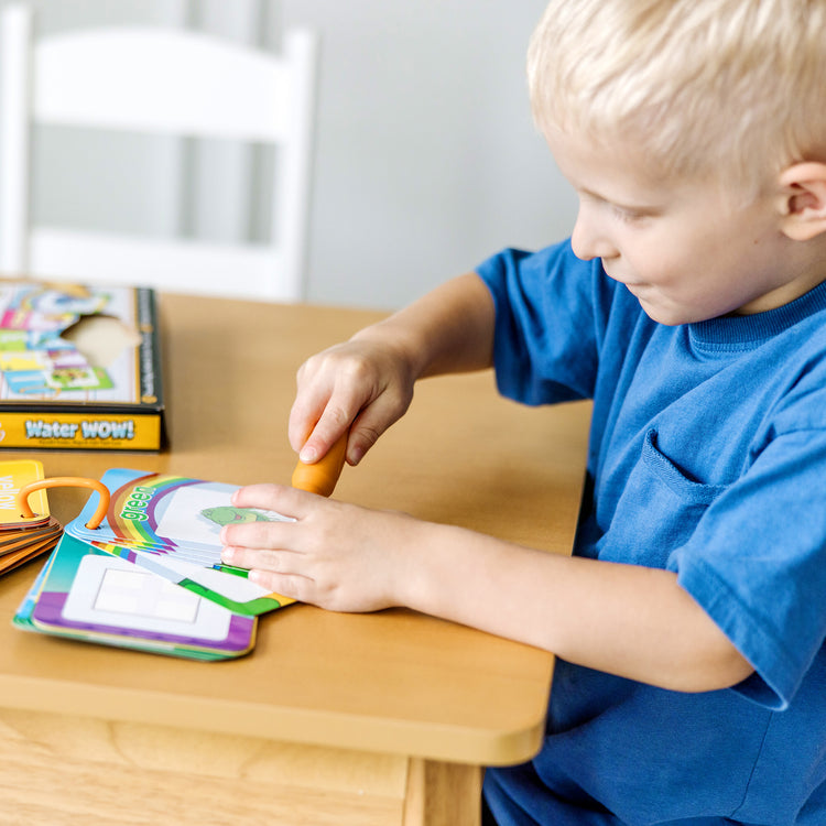 A kid playing with The Doug On the Go Water Wow! Reusable Water-Reveal Cards - Shapes, Numbers, Colors