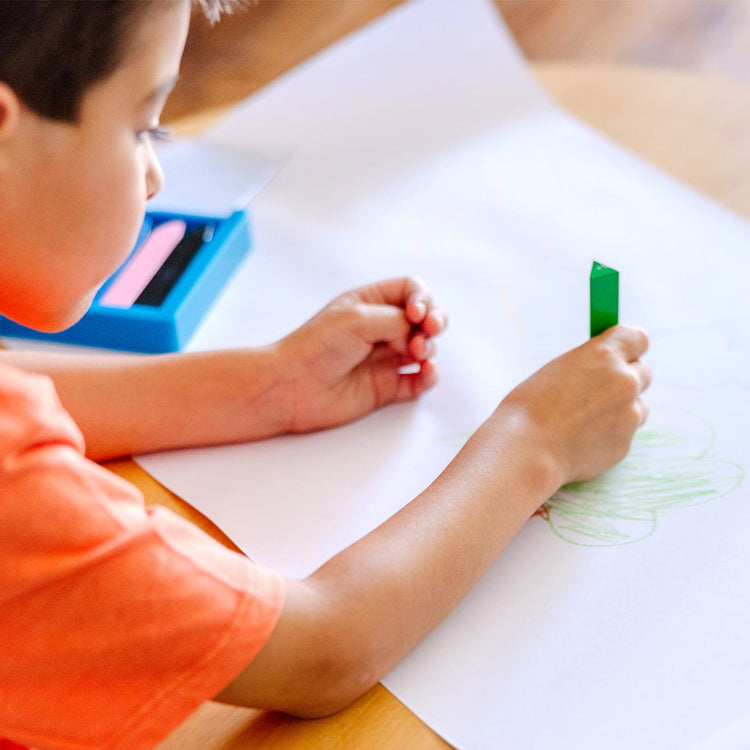 A kid playing with the Melissa & Doug Tabletop Easel Paper Roll (12 inches x 75 feet)