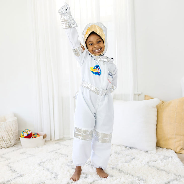 A kid playing with the Melissa & Doug Astronaut Costume Role Play Space Set (5 pcs) - Jumpsuit, Helmet, Gloves, Name Tag