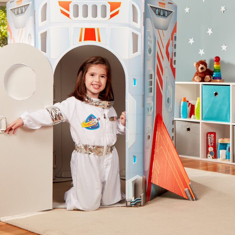 A kid playing with the Melissa & Doug Astronaut Costume Role Play Space Set (5 pcs) - Jumpsuit, Helmet, Gloves, Name Tag