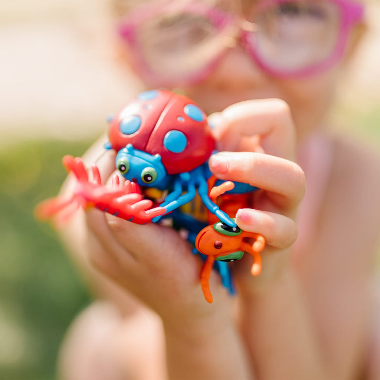 A kid playing with the Melissa & Doug Sunny Patch Bag of Bugs (10 pcs)